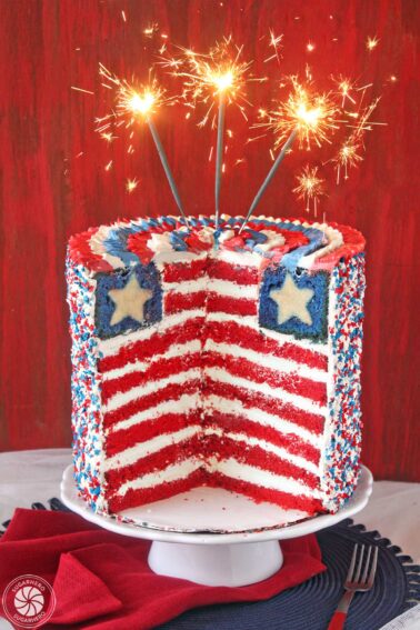 An American Flag Layer Cake with slices cut away to show interior layers.