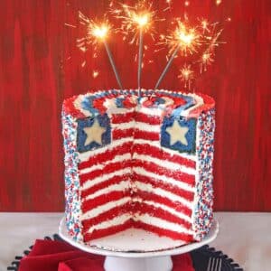 Close up of an American Flag Layer Cake with slices cut away to show the inside.