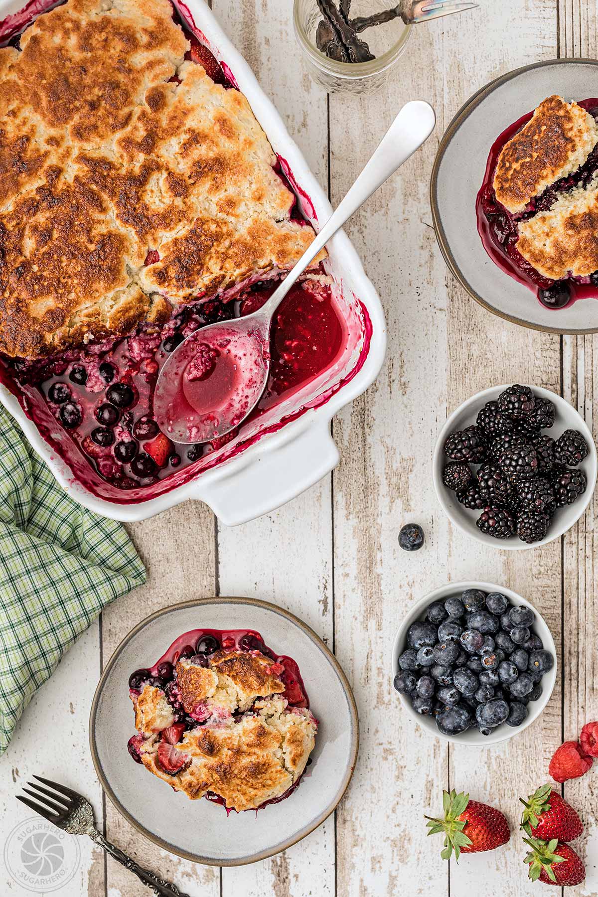 Overhead shot of dish of berry cobbler with a portion scooped out
