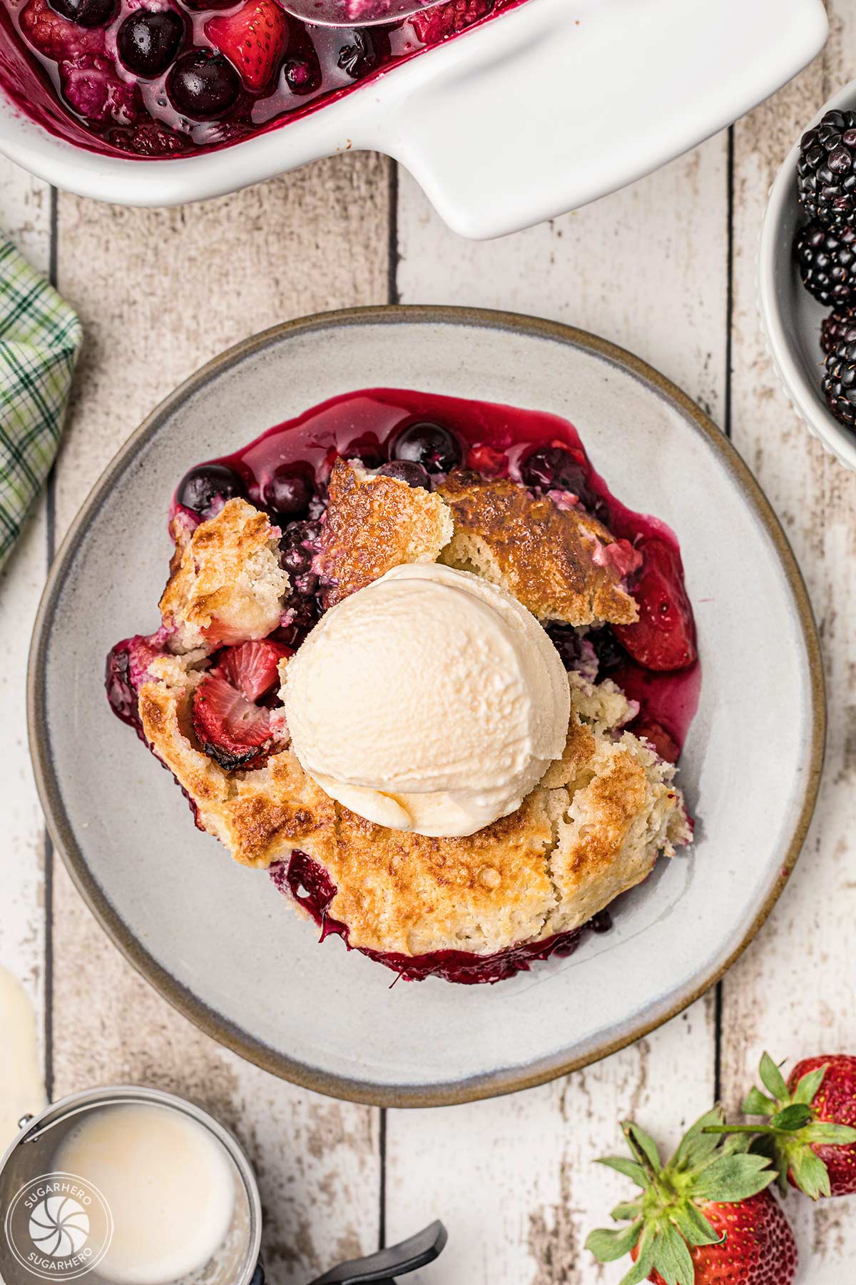 Overhead shot of a plate of berry cobbler with a scoop of ice cream on top