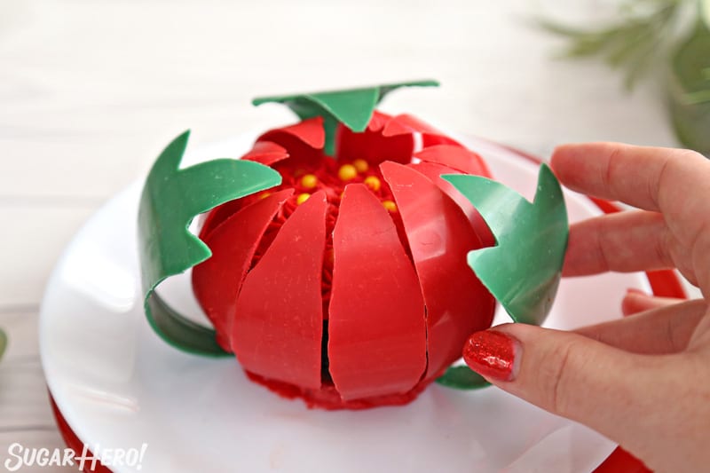 Blooming Chocolate Flowers - placing green chocolate leaves around the base of blooming chocolate flowers | From SugarHero.com