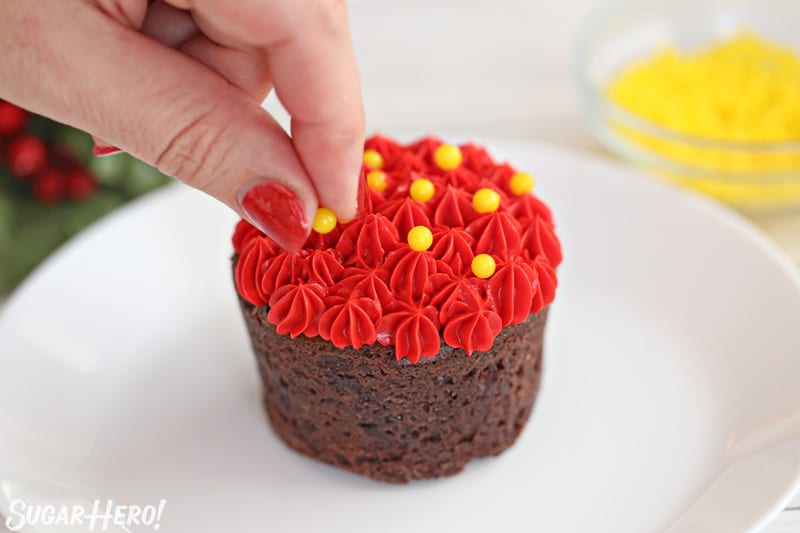 Blooming Chocolate Flowers - decorating the tops of peppermint mocha brownie cups with red frosting stars and yellow sugar pearls | From SugarHero.com