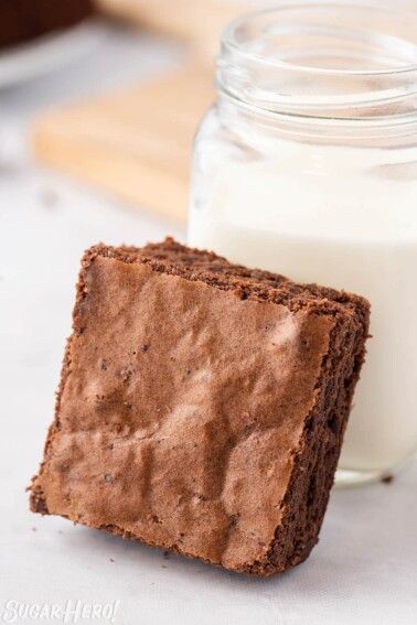 Brown Butter Brownie leaning against a mason jar of milk