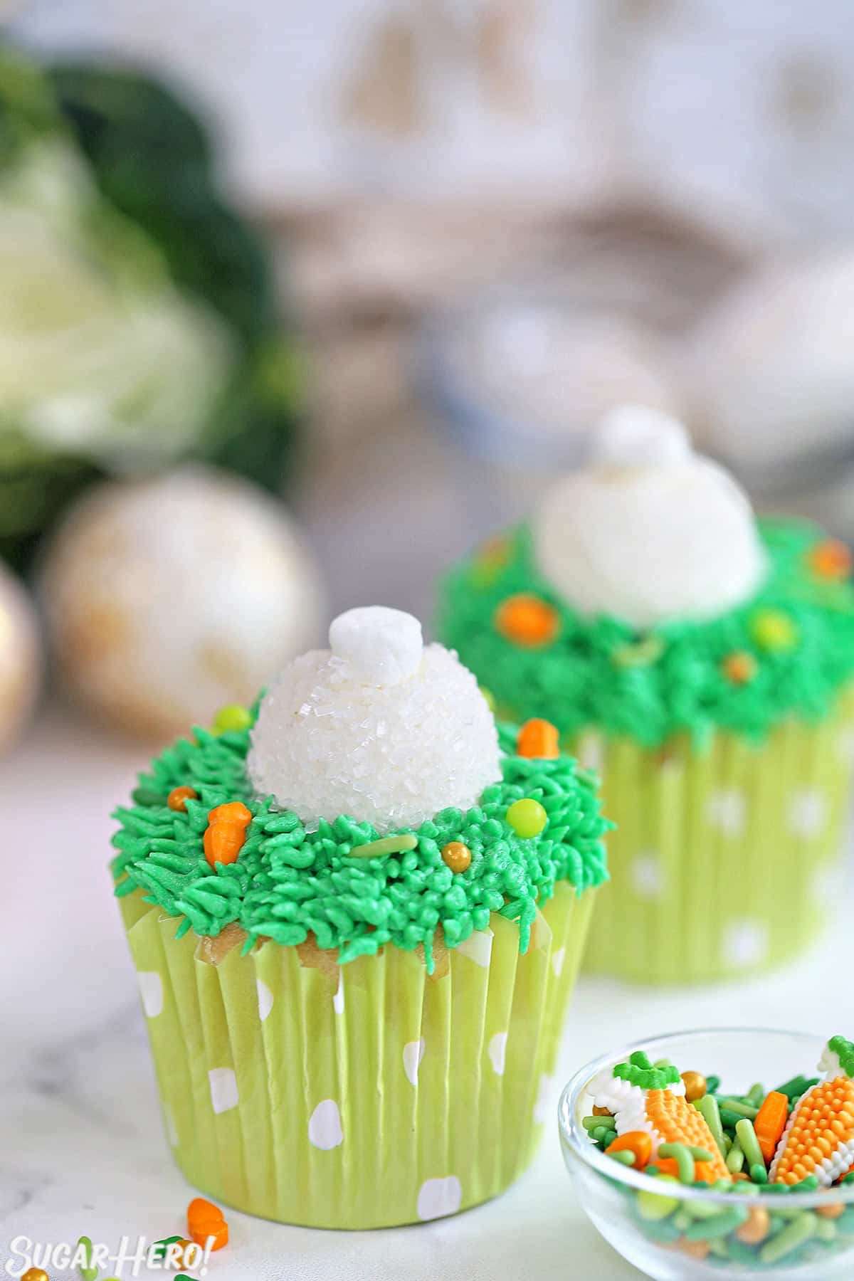 2 Bunny Butt Cupcakes next to a small bowl of Easter candies.