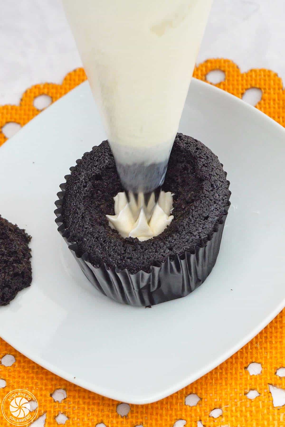 Piping white buttercream into the center of a Piping orange buttercream on a Candy Corn Cupcake.