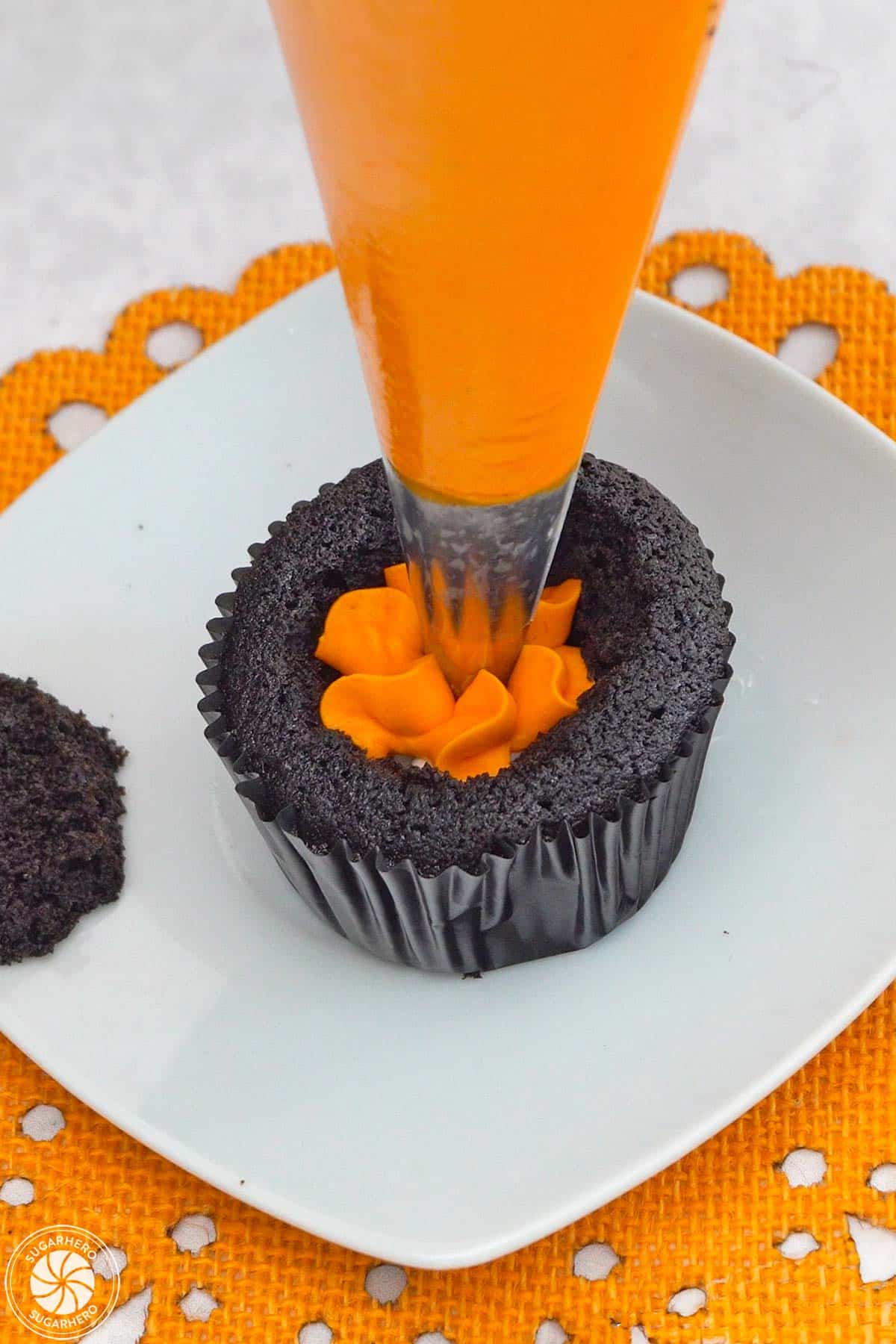 Piping orange buttercream into the center of a Piping orange buttercream on a Candy Corn Cupcake.