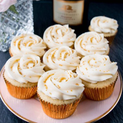 7 Champagne Cupcakes on a pink plate.
