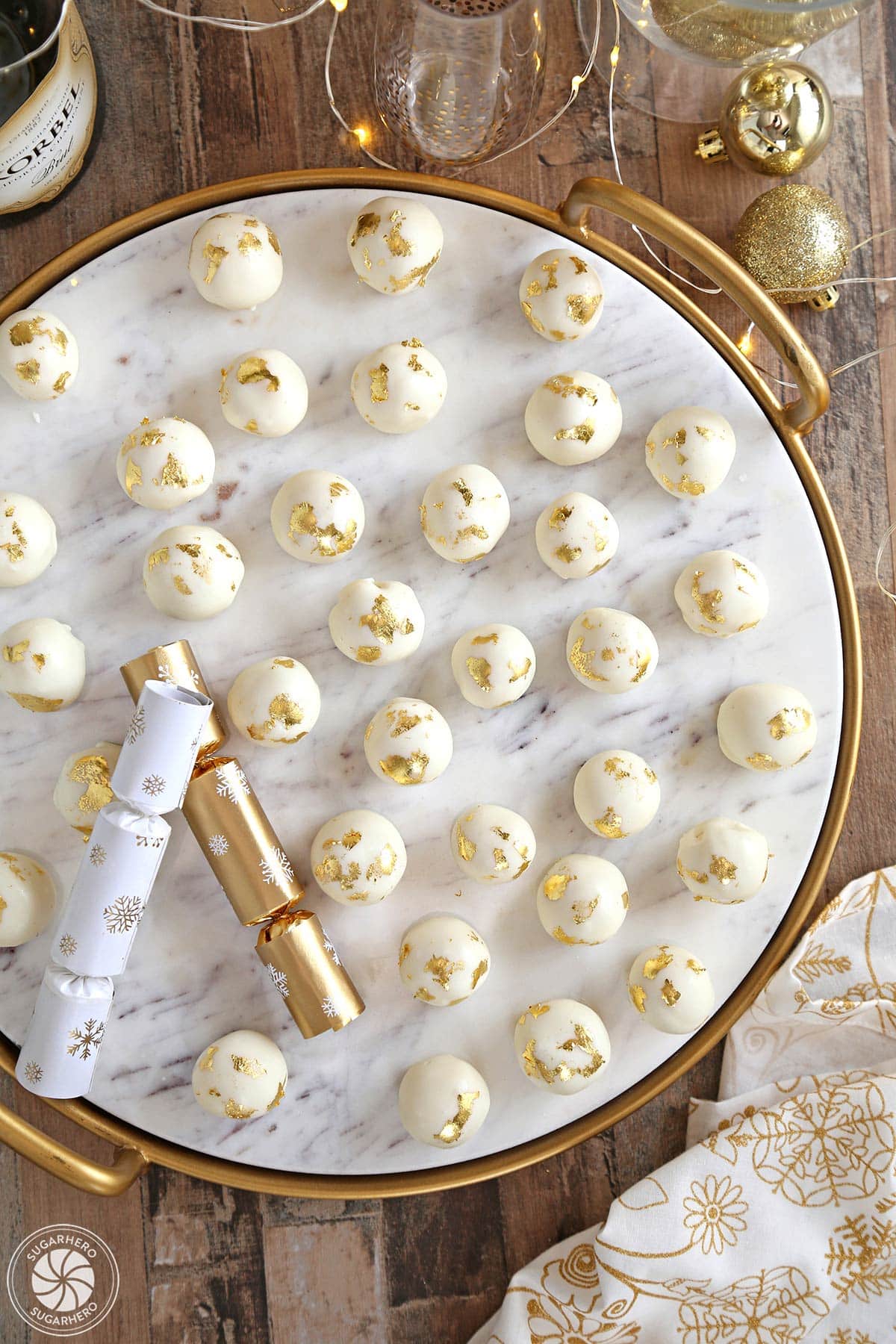 Overhead shot of Champagne White Chocolate Truffles on a white marble tray with party poppers