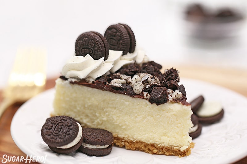 Slice of cheesecake with crumbled Oreo cookies on top.