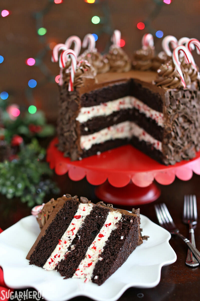 Chocolate Candy Cane Cake &ndash; full cake on a cake stand, with a single slice removed and placed on a cake in front | From SugarHero.com
