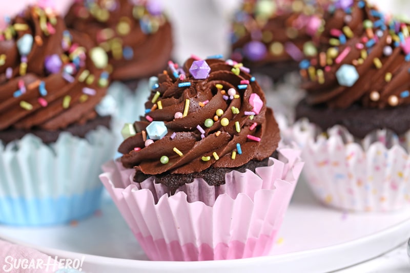 Close-up of moist chocolate cupcake with chocolate frosting and sprinkles on top