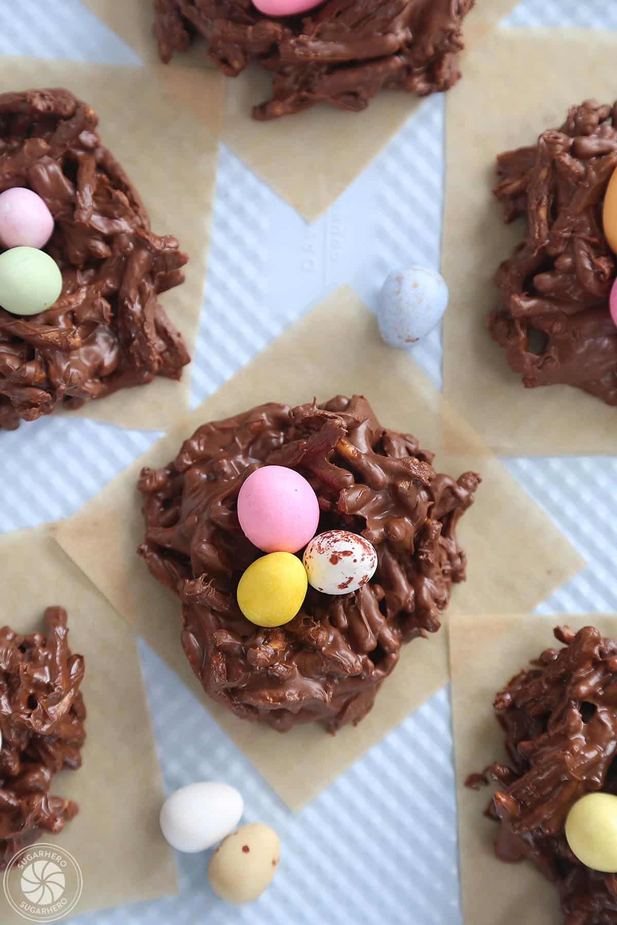 Top view of Chocolate Easter Nests on brown parchment on a blue baking sheet.