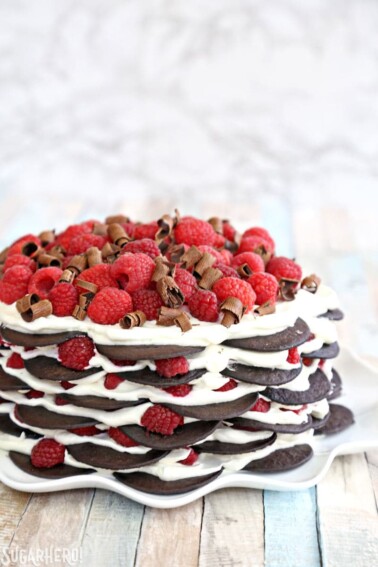 A Chocolate Raspberry No-Bake Cake on a white ruffled cake plate.