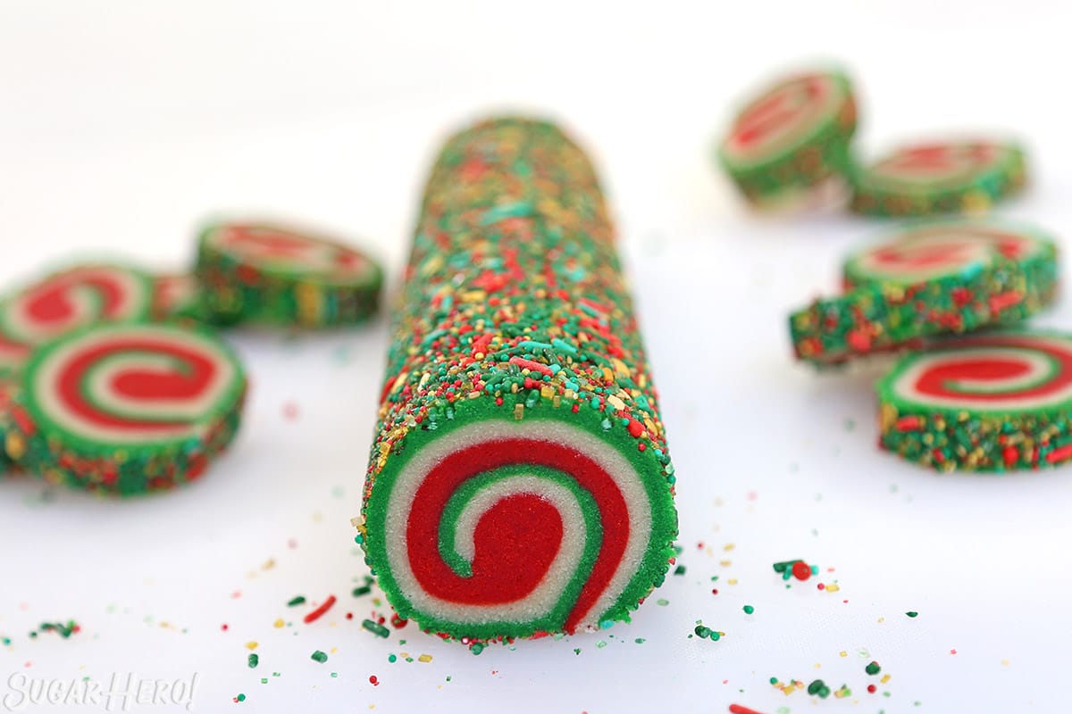 Log of red, white, and green cookie dough in a spiral design.