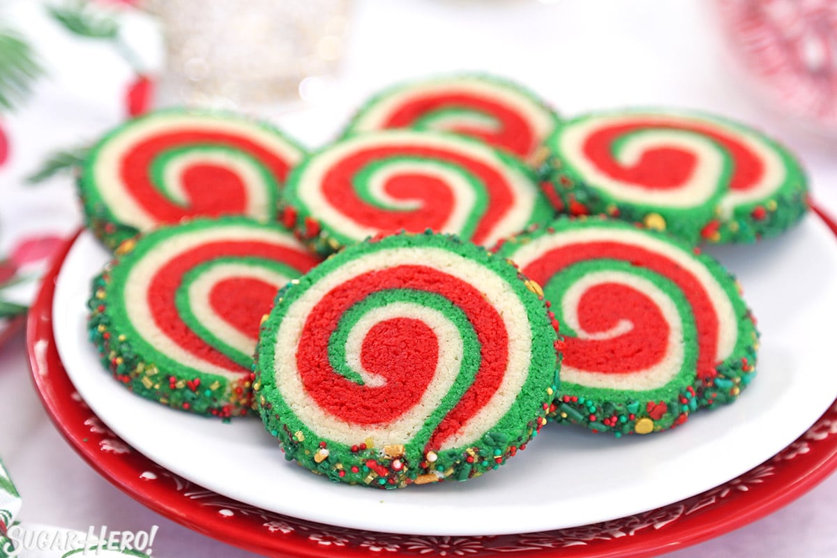 Red, white, and green Christmas Pinwheel Cookies arranged on a red and white plate.
