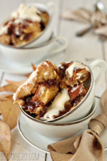A scoop of Cinnamon Bun Bread Pudding in a white bowl with silver trim.