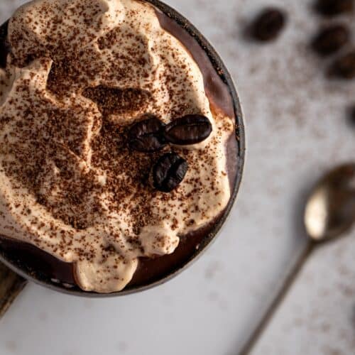 Top view of Coffee Hot Chocolate embellished with coffee whipped cream and coffee beans.