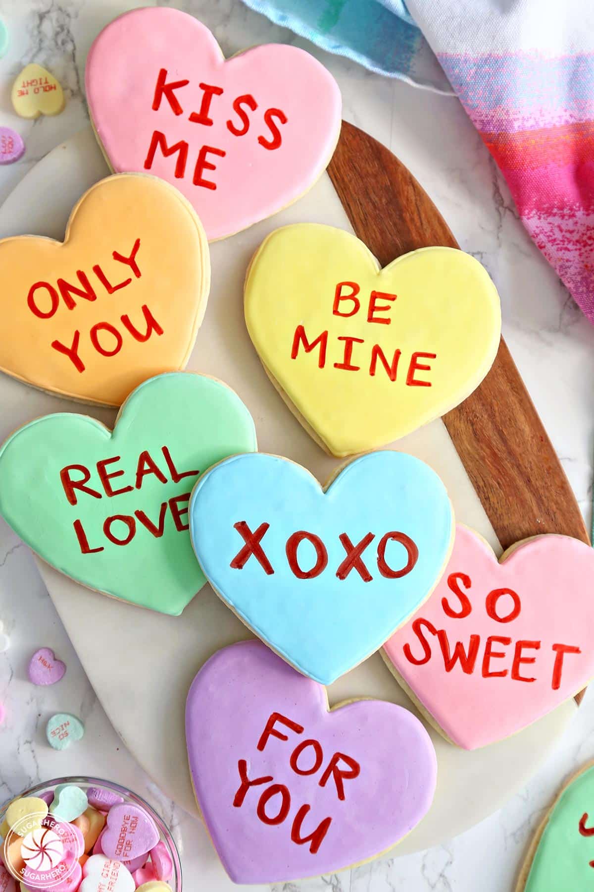 Top view of Conversation Heart Sugar Cookies on a cutting board.