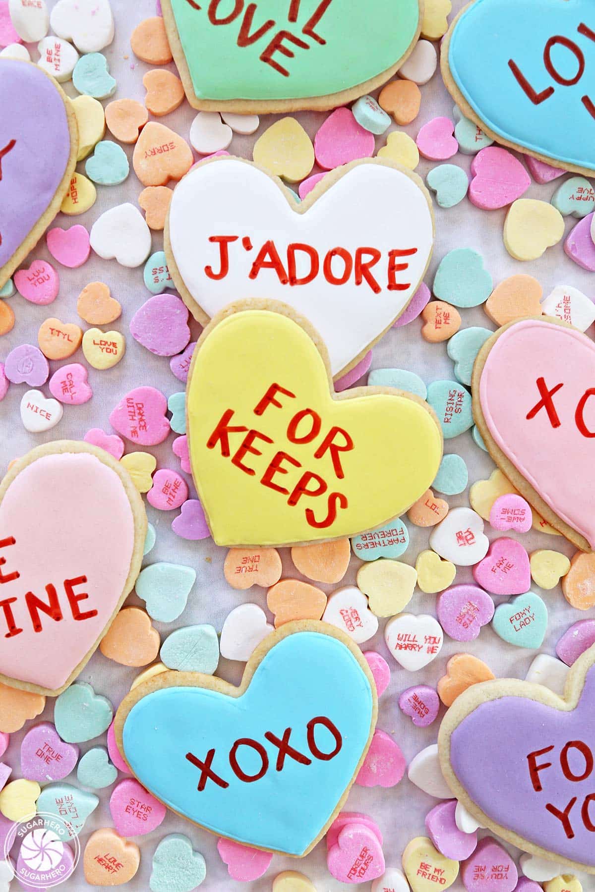 Conversation Heart Sugar Cookies sitting on top of candy conversation hearts.