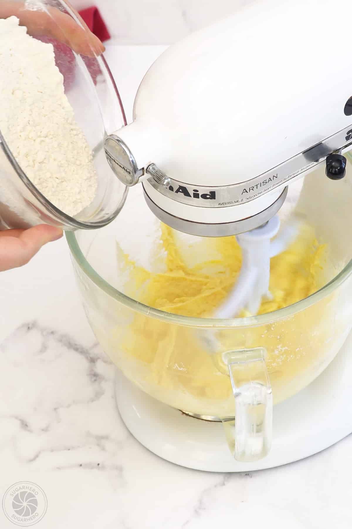 Adding dry ingredients to the cake batter.