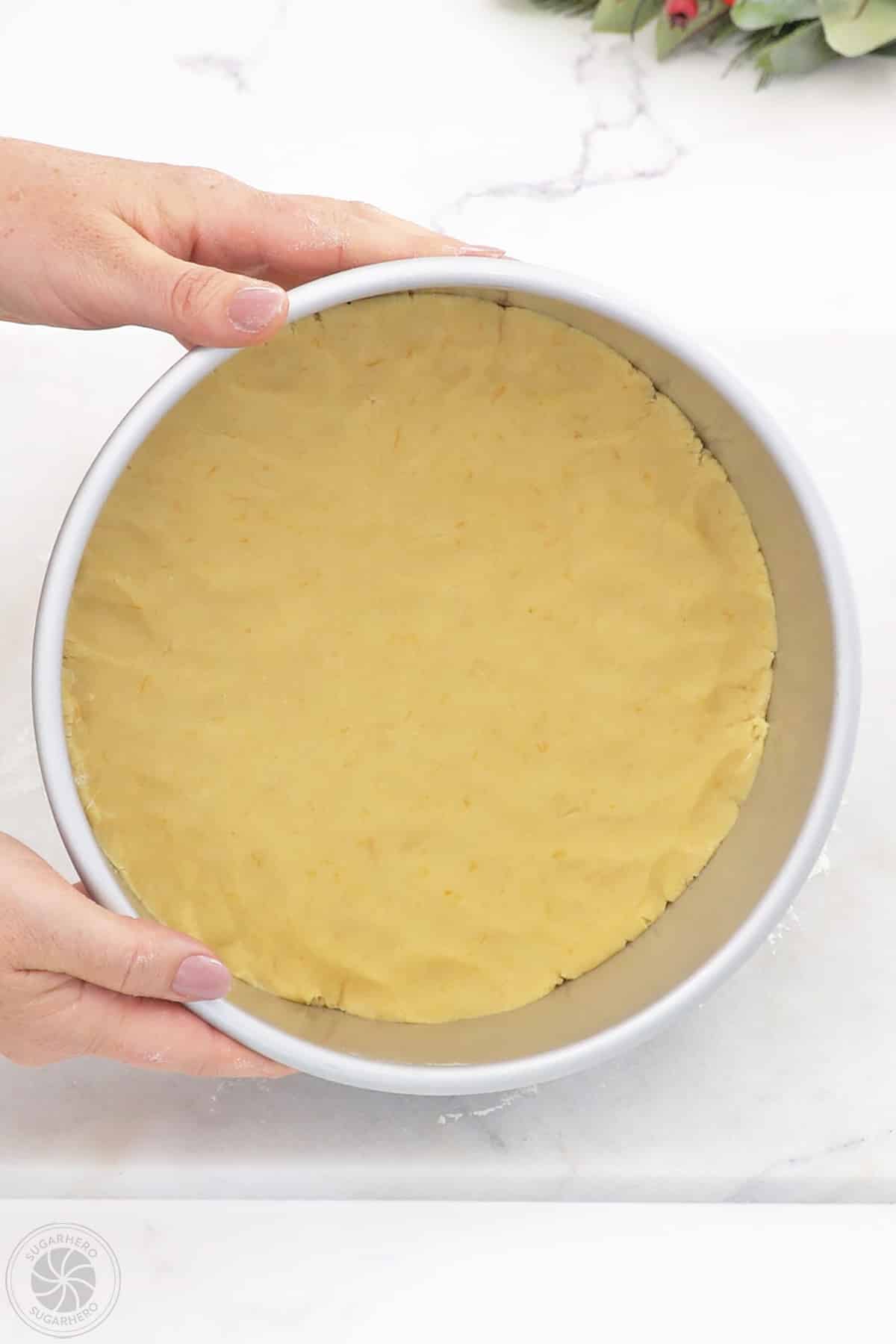 Dough pressed into the bottom of a cake pan.