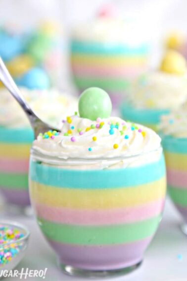 Pastel rainbow gelatin cup with a spoon sticking out of the top.