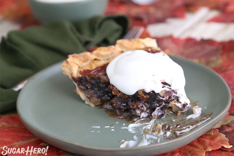 Deep Dish Pecan Pie - half-eaten piece of pie with whipped cream on top | From SugarHero.com