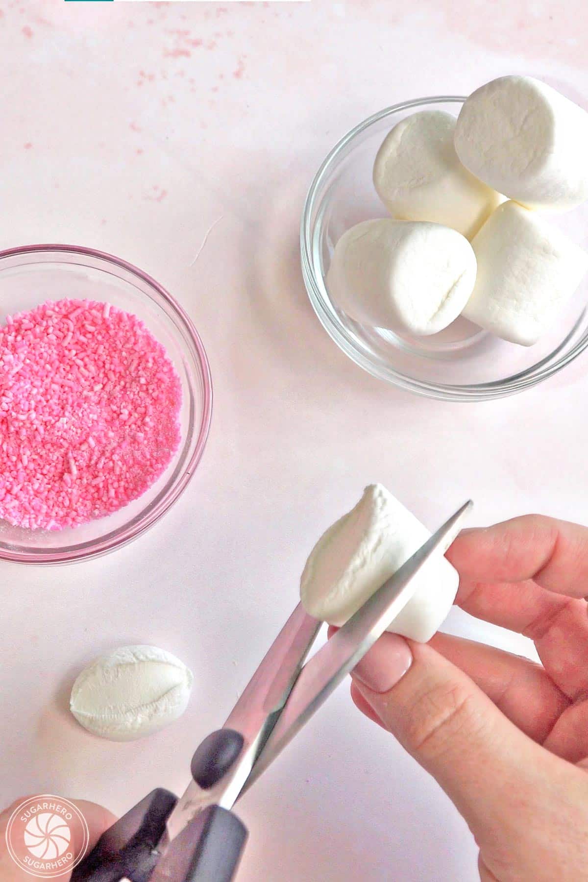 Cutting large marshmallows into smaller pieces.