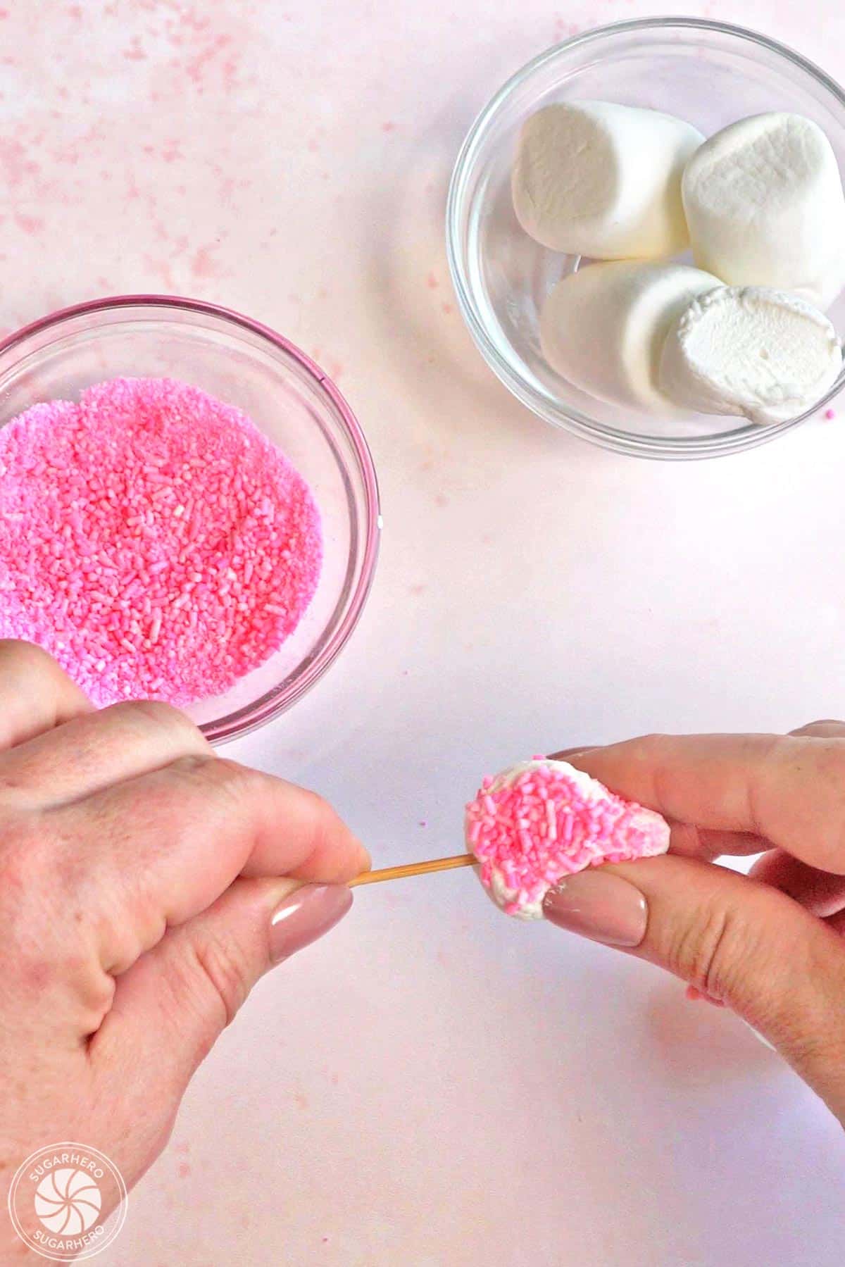 Pushing a skewer into a marshmallow ear.