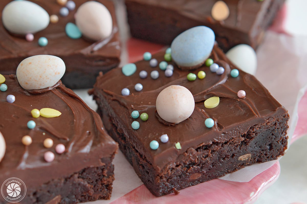Easter Egg Brownies on a white plate with colorful Cadbury mini chocolate eggs on top.