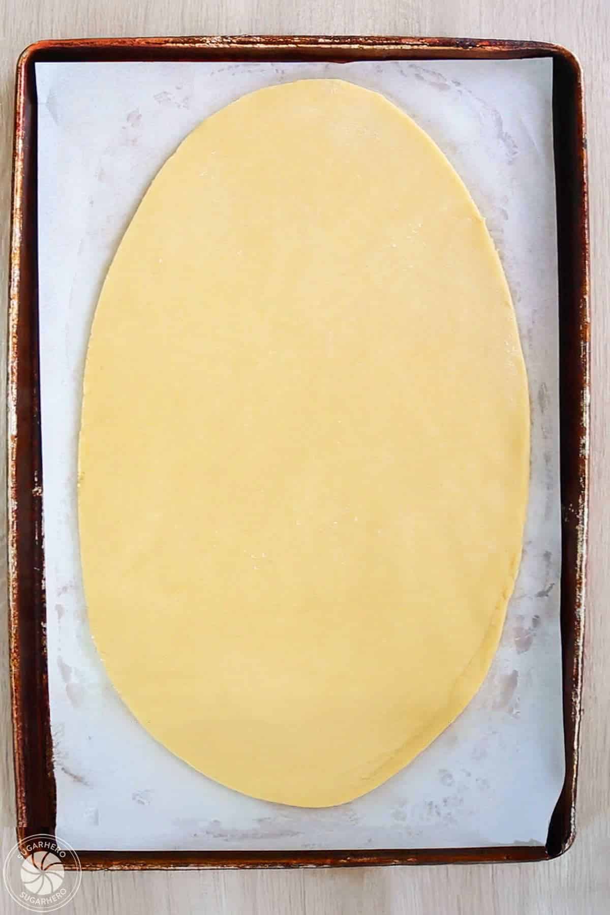 Sugar cookie dough on a baking sheet in the shape of an egg.