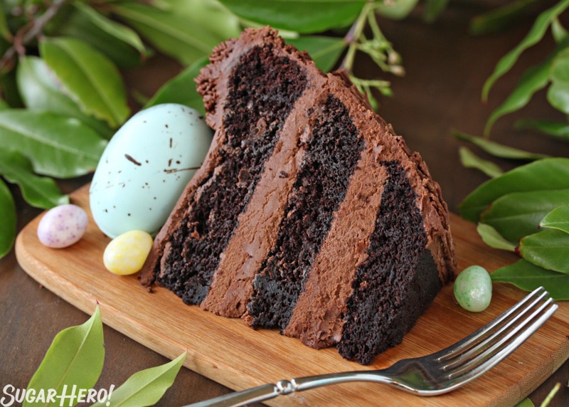 Slice of Easter Nest Cake surrounded by candy eggs and a fork.