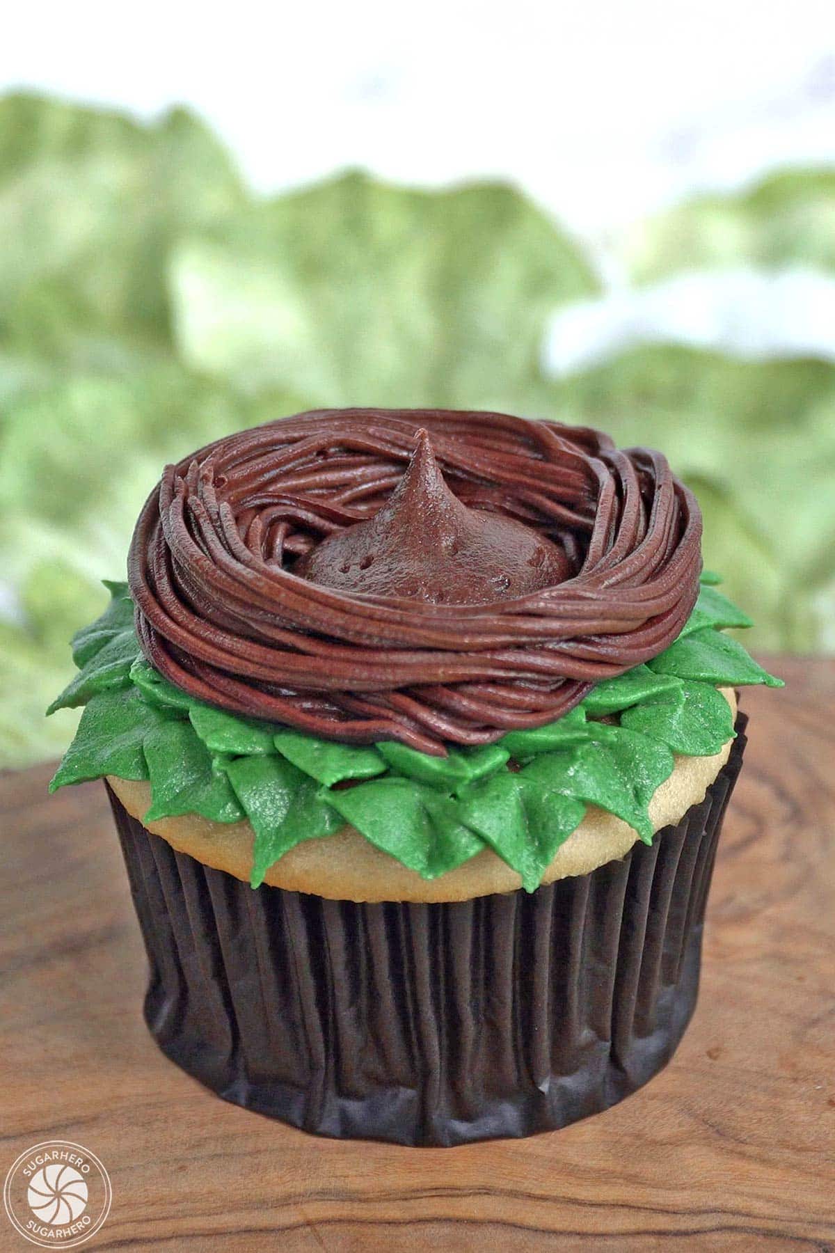 Adding a big mound of chocolate buttercream in the center of a buttercream nest.