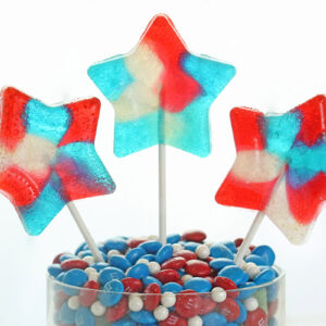Three star lollipops in a glass jar of candy.