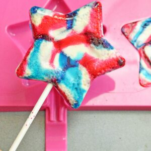 Hand holding up a star-shaped lollipop.