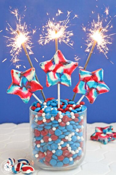 3 star lollipops in a jar of red white and blue candy.