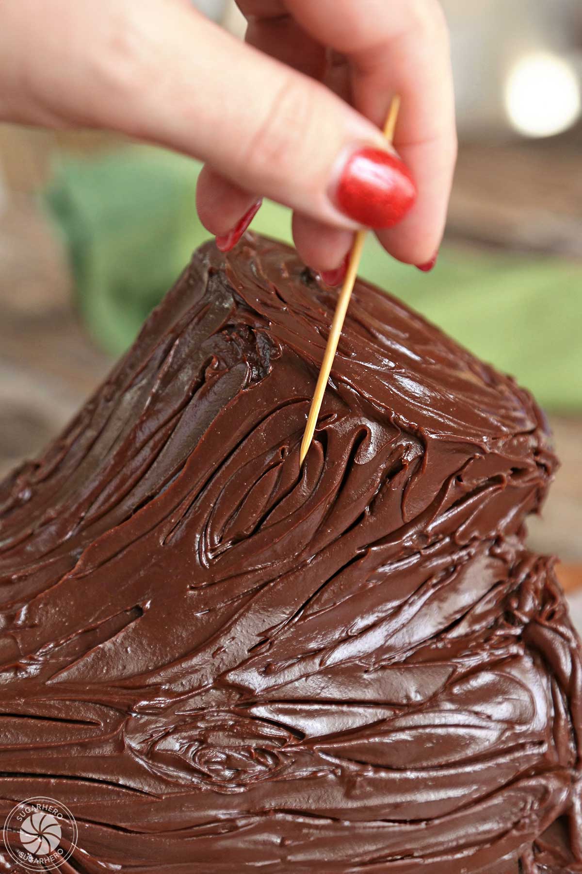 Using a toothpick to add fine details to the log texture in the ganache.