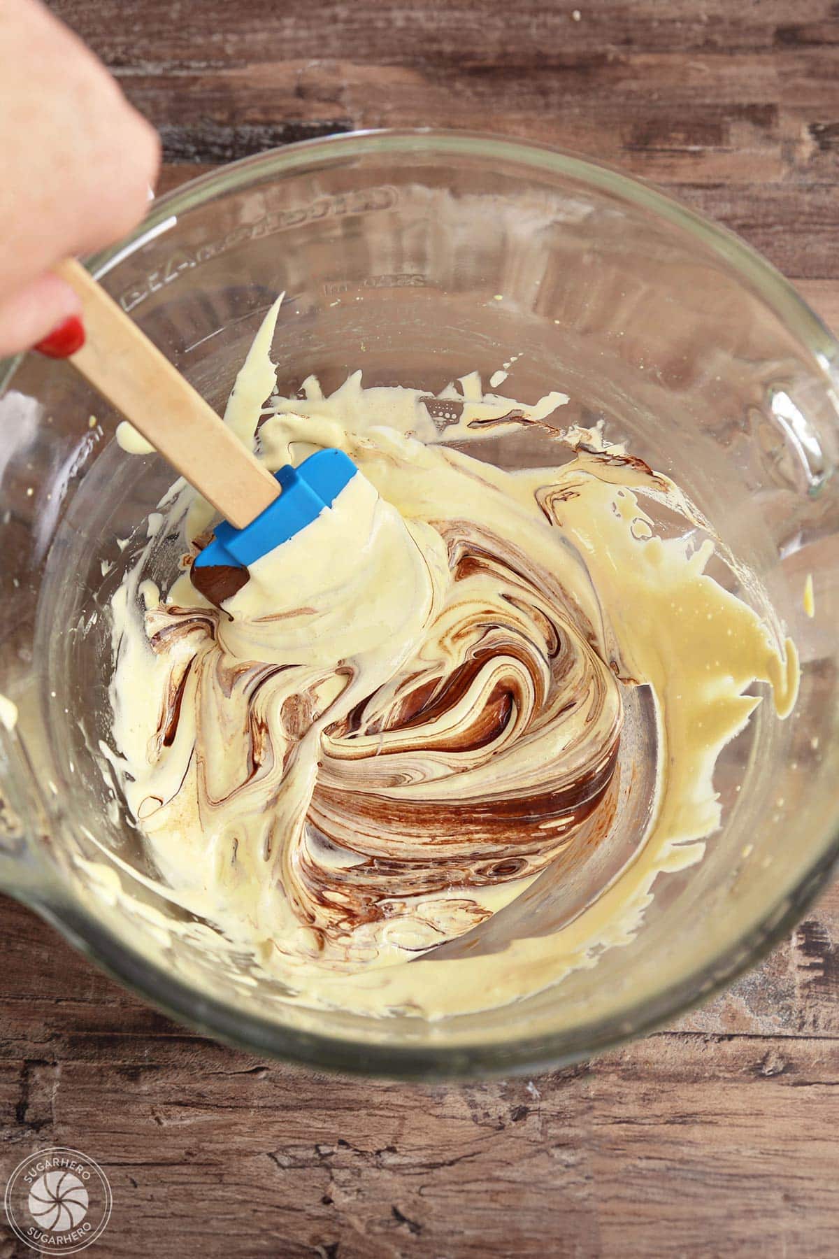 Egg yolk mixture being stirred together with melted chocolate.