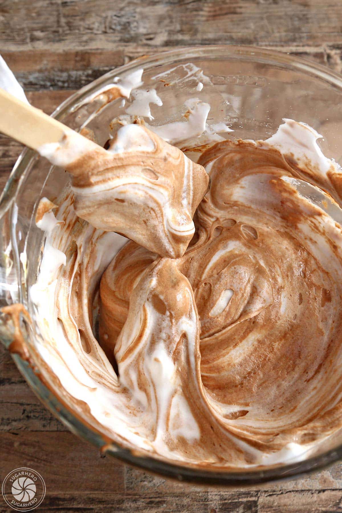 Gently folding together egg white mixture and chocolate egg yolk mixture.