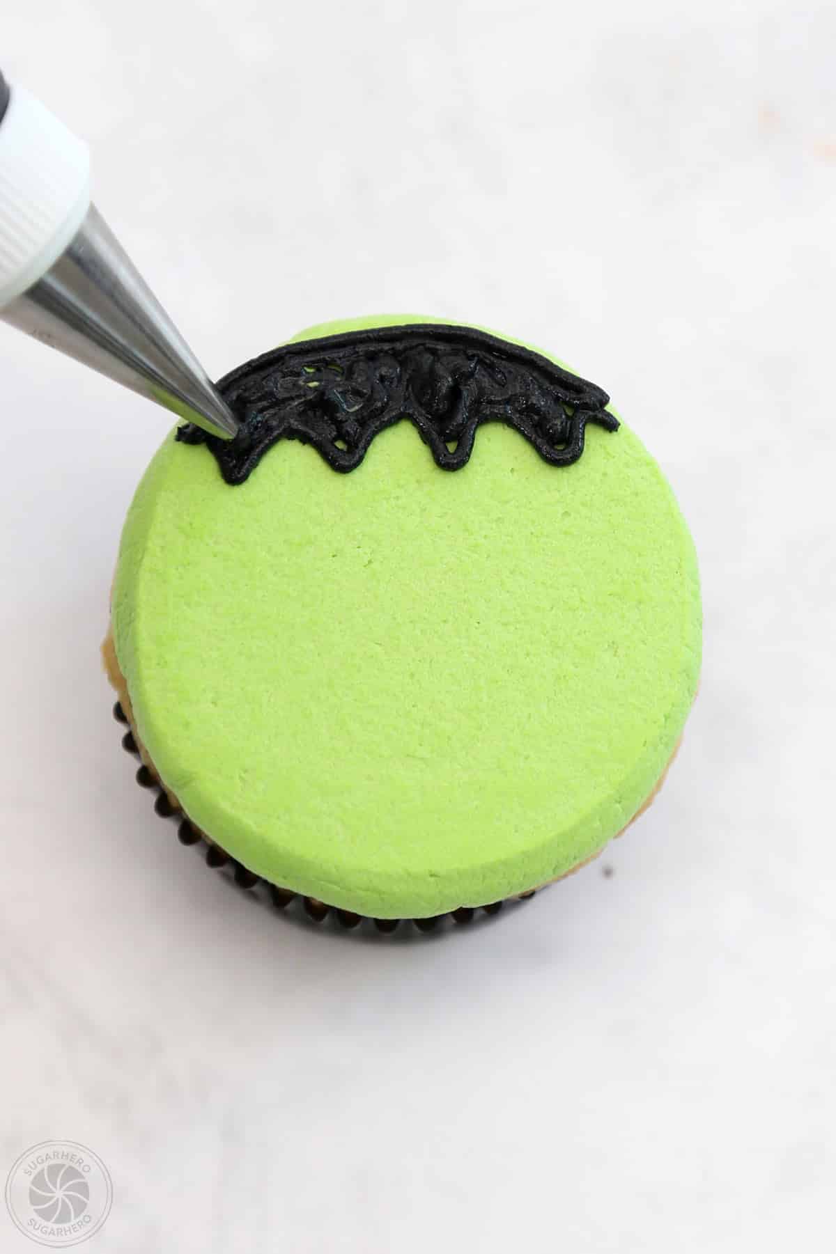 Frankenstein Cupcake with black hair piped on top.