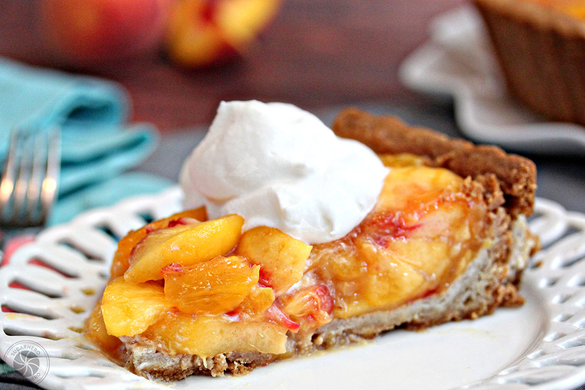 A slice of Fresh Peach Tart on a white plate with a dollop of whipped cream.