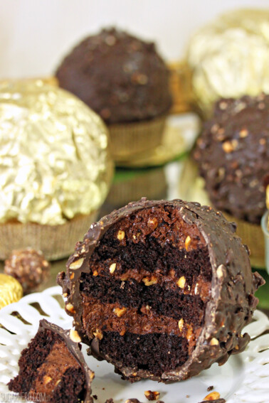 Close up of a Giant Ferrero Rocher Hazelnut Mousse Cake with portion cut away to show inside layers.