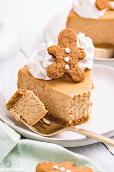 Slice of Gingerbread Cheesecake on a white plate with a bite removed on a fork.