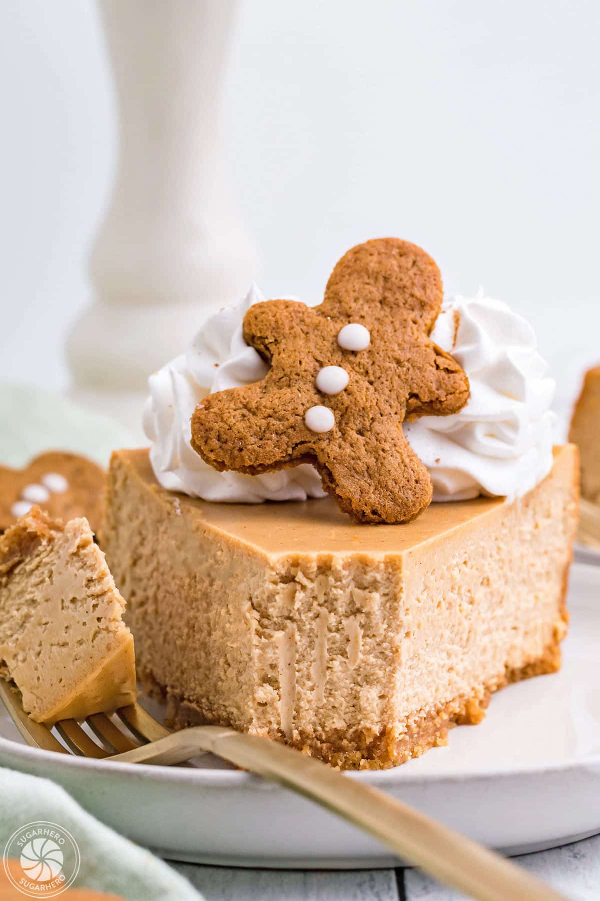 Slice of Gingerbread Cheesecake on a white plate with a bite removed on a fork.