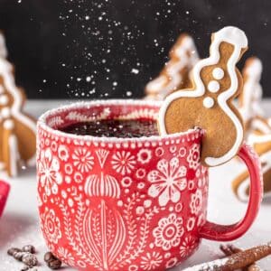 Tree-shaped Gingerbread Cookie Mug Topper on the edge of a red and white mug