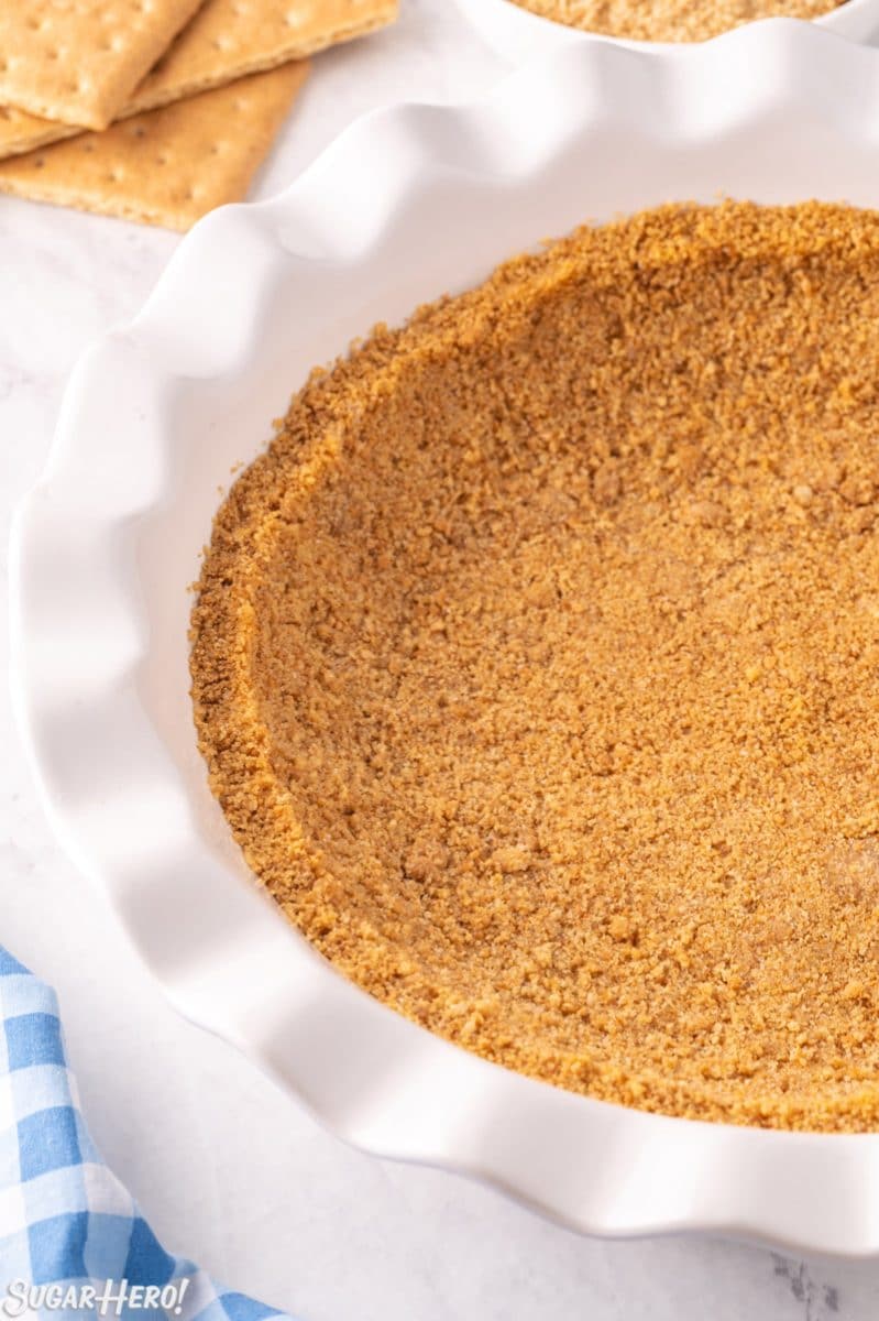 Photo of graham cracker crust in a white pie pan.