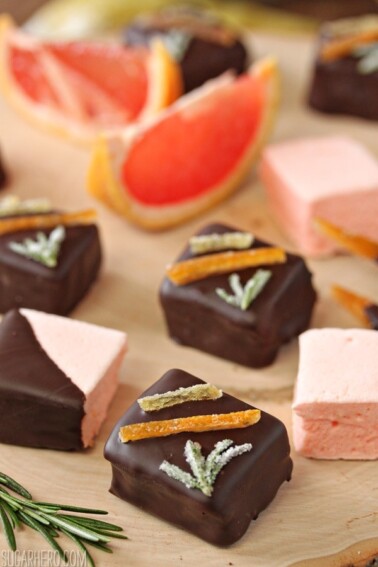 Grapefruit Marshmallows on a wooden surface next to rosemary.