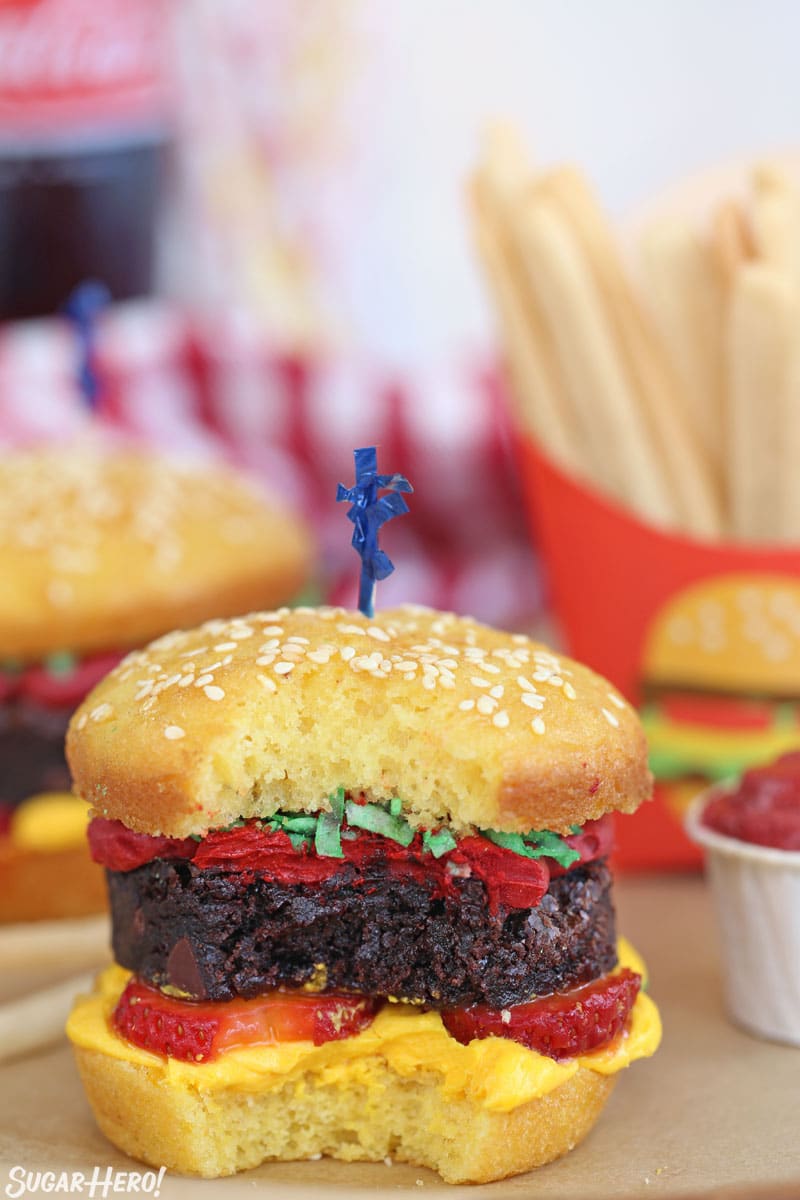 A hamburger cupcake with a bite taken out of it.