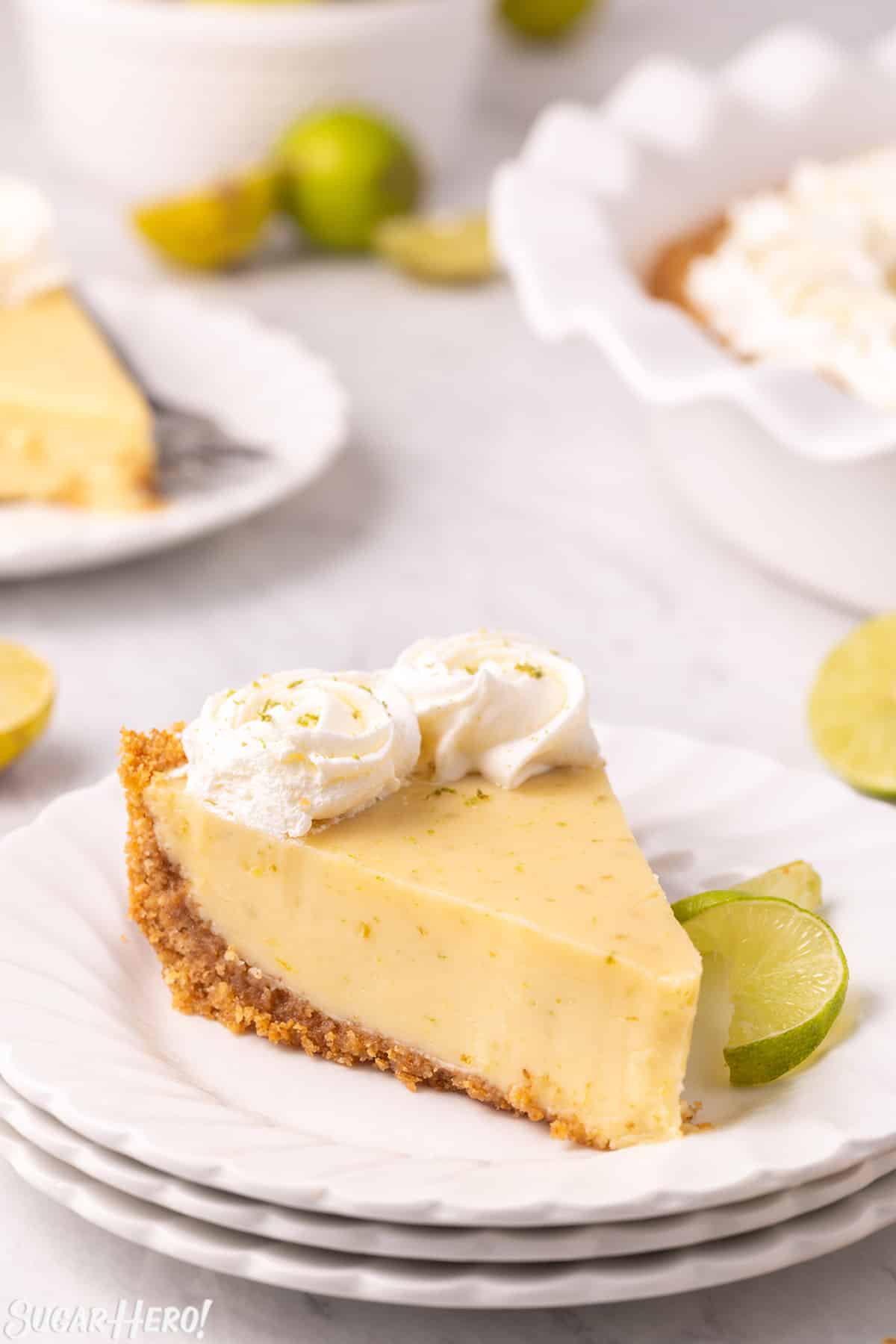 Photo of a slice of key lime pie on 3 stacked rounded white plates.