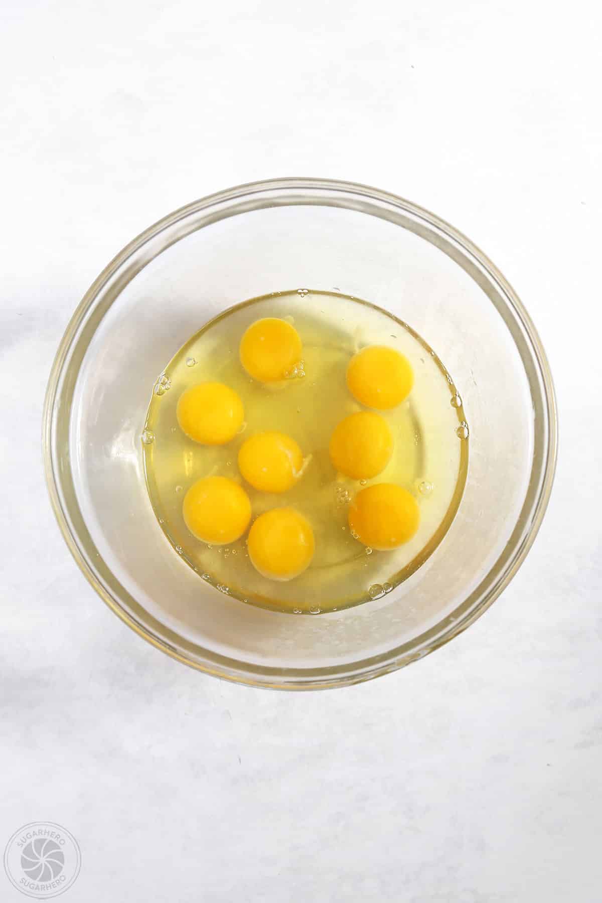 Cracked eggs in a clear mixing bowl.